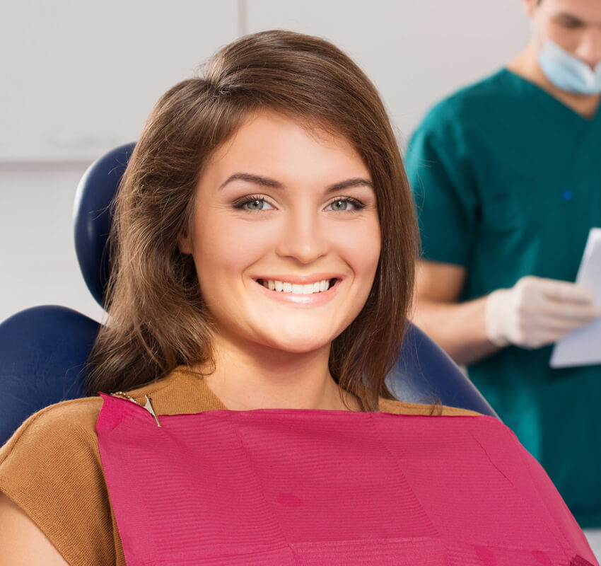 A lady smiling on a dental chair